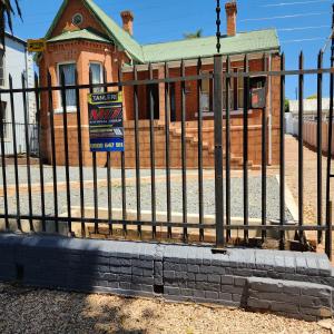 una valla de hierro frente a un edificio en Msunduzi River View backpackers, en Pietermaritzburg