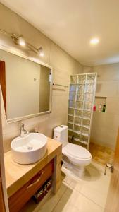 a bathroom with a sink and a toilet and a mirror at San Angel Villas in San Antonio