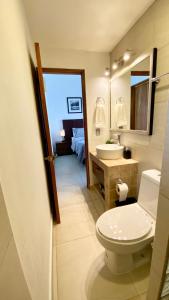 a bathroom with a toilet and a sink and a mirror at San Angel Villas in San Antonio