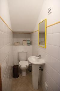 a bathroom with a toilet and a sink at Oliveira Beach House in Longueira