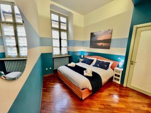 1 dormitorio con 1 cama con rayas azules y blancas en Novantasette passi dal Duomo by Revenue House, en Casale Monferrato