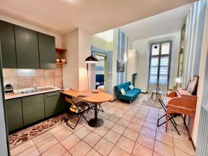 een keuken met een tafel en een woonkamer bij Novantasette passi dal Duomo in Casale Monferrato