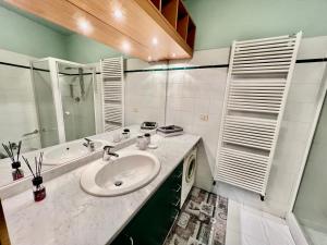 een badkamer met een wastafel, een bad en een spiegel bij Novantasette passi dal Duomo in Casale Monferrato