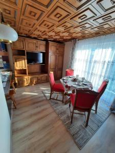 a dining room with a table and red chairs at Mały Domek in Zwardoń