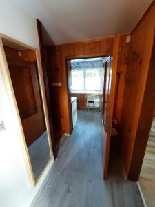 a hallway with a door and a room with a table at Mały Domek in Zwardoń