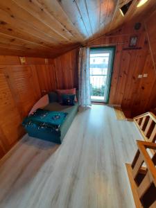ein Wohnzimmer mit einem Sofa in einem Holzzimmer in der Unterkunft Mały Domek in Zwardoń
