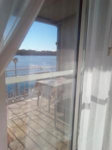 a balcony with a table and a view of the water at Apartment Ljilja in Blato