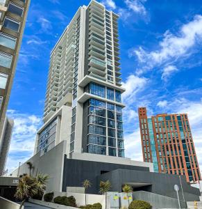 a tall building with palm trees in front of it at Apartamento Reñaca Live in Viña del Mar