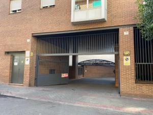 a large brick building with a large garage at Apartamento en Madrid Rio con Parking Gratuito in Madrid