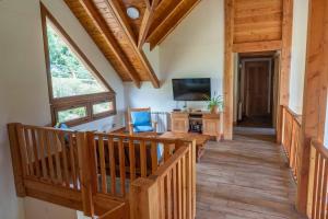 Habitación con escalera, suelo de madera y TV. en Casa Santa Clara en San Carlos de Bariloche