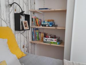 een slaapkamer met een bed en planken met boeken bij Côté Château in Gaillon