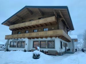 ein großes Haus mit Schnee davor in der Unterkunft Das Unterwimm in Wagrain