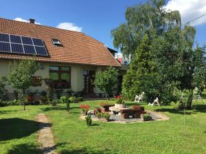 una casa con giardino dotato di tavolo e pannelli solari di Katalin vendégház a Sárospatak