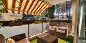 a balcony with wicker chairs and tables on a patio at Le Silène in Sainte-Maxime