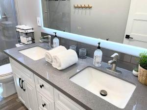 um balcão de casa de banho com dois lavatórios e um espelho em Luxurious Brownstone Retreat - Walk to DT/Golden1 em Sacramento