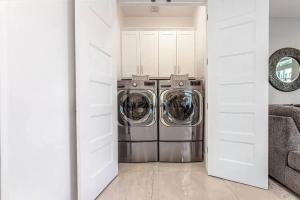 a washer and dryer in a white laundry room at Luxurious Brownstone Retreat - Walk to DT/Golden1 in Sacramento