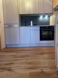 uma cozinha com electrodomésticos brancos e piso em madeira em Appartement Melinda Ebnit em Dornbirn
