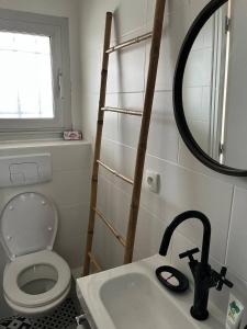 ein Badezimmer mit einem WC, einem Waschbecken und einem Spiegel in der Unterkunft Appartement T2 - port d'Orange in Saint-Pierre-Quiberon
