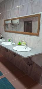 uma casa de banho com 2 lavatórios e um espelho em Petra cabin Roof top hostel em Wadi Musa