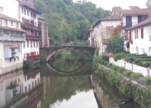 a bridge over a river in a town with buildings at La vita e bella in Saint-Jean-Pied-de-Port