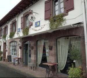 un edificio con una mesa delante en La vita e bella en Saint-Jean-Pied-de-Port