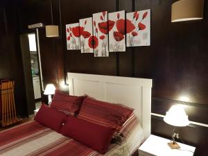 1 dormitorio con 1 cama con flores rojas en la pared en Islavinia en Tigre