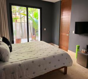 ein Schlafzimmer mit einem großen Bett und einem großen Fenster in der Unterkunft Kin Tulum - Puerta Azul Luxury in Tulum