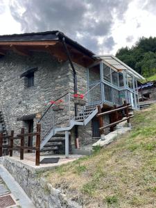 una casa in pietra con una scala sul lato di Grandze du Pleiney a Saint-Rhémy-en-bosses