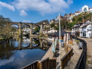 a bridge over a river in a town with houses at Sleepy Hollow Holiday Home in Knaresborough