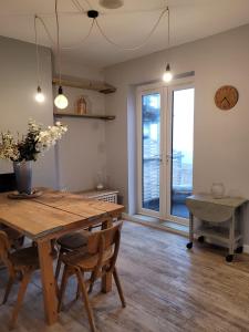 a dining room with a wooden table and a large window at Sea View Sandgate in Sandgate