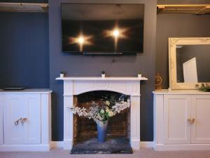 a fireplace with a tv on top of it at Sea View Sandgate in Sandgate