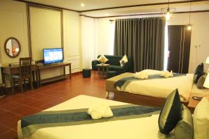 una camera d'albergo con due letti e una televisione di Confetti Garden Resort a Vang Vieng