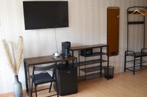 Zimmer mit einem Schreibtisch und einem TV an der Wand in der Unterkunft Hotel Harzer am Kurpark in Bad Herrenalb