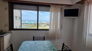 a bedroom with a table and a window with a view at Apart Hotel Santa Lucia in Mar del Plata