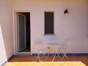パリヌーロにあるCountry House Itaca Palinuroの壁掛けのテーブルと椅子