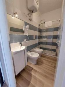 bagno con lavandino, servizi igienici e specchio di Country House Itaca Palinuro a Palinuro