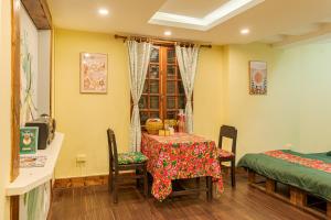 a room with a table and chairs and a window at Hanoi Retro 80S Homestay in Hanoi