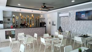 un comedor con mesas blancas y sillas blancas en Hotel Plaza Coral en Punta Cana