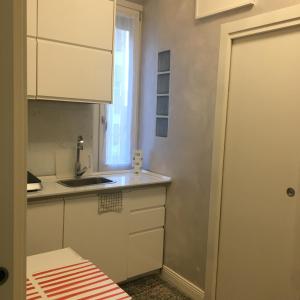 eine kleine Küche mit einem Waschbecken und einem Fenster in der Unterkunft Studio Monte Ceneri in Mailand
