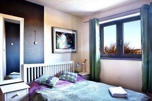 a bedroom with a bed and a window at A cosy house near the city centre in Glasgow +19 photos