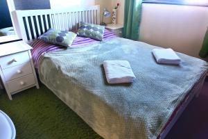 a bedroom with a bed with two towels on it at A cosy house near the city centre in Glasgow
