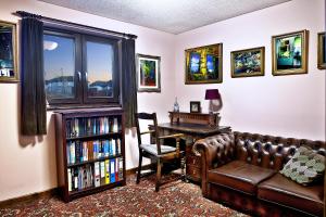 ein Wohnzimmer mit einem Sofa, einem Tisch und einem Bücherregal in der Unterkunft A cosy house near the city centre in Glasgow