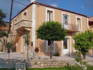 a large house with a tree in front of it at Villa Petra with heated pool in Kalochorafitis