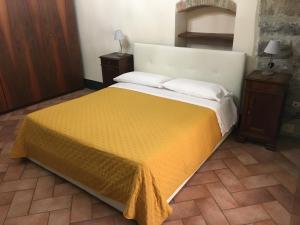 a bedroom with a large bed with a yellow blanket at Casa Mario Lupo - Apartments and Rooms in Bergamo