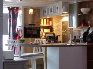 - une cuisine avec un comptoir, 2 chaises et un évier dans l'établissement Au Ptit Coquelicot, à Houyet