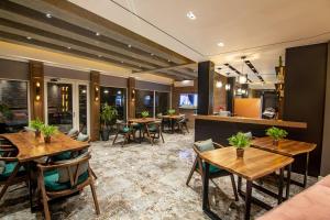 a restaurant with wooden tables and chairs in a room at Tree Hotel in Korçë