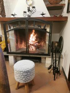 a living room with a fireplace and a white stool at Casa Vacanza Pescocostanzo in Pescocostanzo