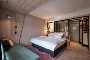 a bedroom with a large white bed and a bench at The Flamingo in Timmendorfer Strand