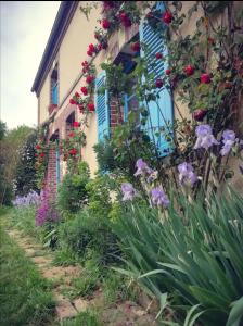 uma casa com flores ao lado dela em La Ferme de Plénoise Chambres d'hôtes 