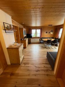 uma sala de estar com pisos em madeira e uma sala de jantar em Appartement Melinda Ebnit em Dornbirn